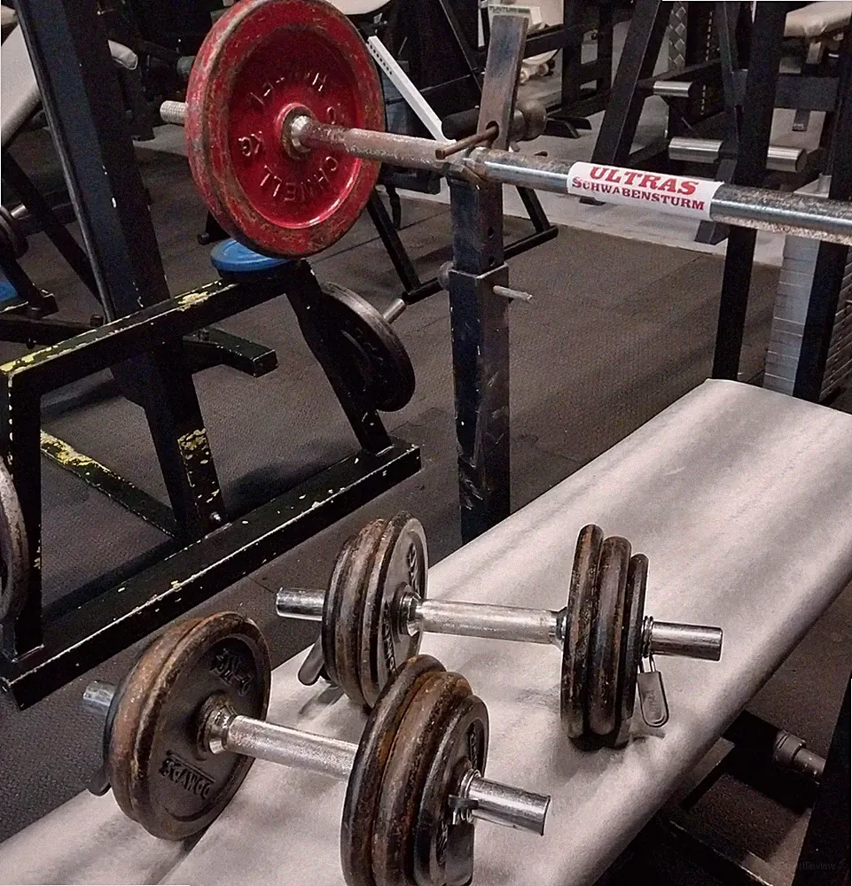 Trainingsbank mit Langhantel und Kurzhanteln